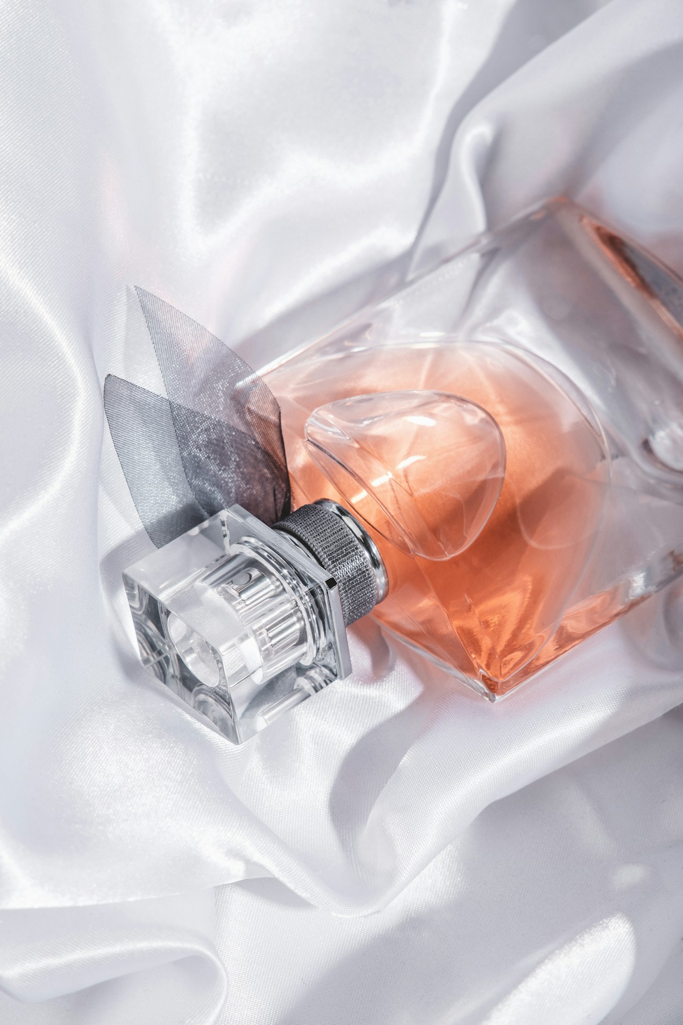 Perfume bottle resting on white silk